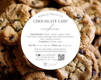 Può includere: Un'etichetta circolare bianca con testo nero su uno sfondo di biscotti con gocce di cioccolato. L'etichetta recita "Whisk & Wheat Co. Chocolate Chip Cookies". Elenca gli ingredienti, il peso netto e la data di produzione. Include anche un nome utente sui social media, un indirizzo e un codice QR.