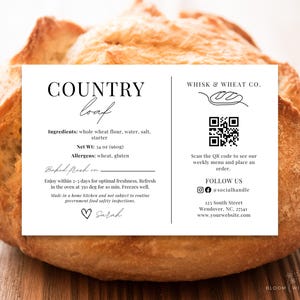 May include: A golden-brown country loaf of bread with a white label. The label states "COUNTRY loaf" and lists ingredients, net weight (397g), and allergens. It also includes a QR code and social media details.