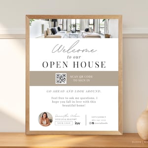 Könnte beinhalten: Ein gerahmtes Schild mit der Aufschrift "Welcome to our Open House". Es enthält einen QR-Code und Maklerdetails. Das Schild steht auf einer Holzoberfläche. Das Schild soll Besucher willkommen heißen.