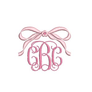 May include: A pink embroidered monogram with the letters "CBC" in a decorative script font. Above the monogram is a pink bow with a small flower in the center. The design is on a white background.