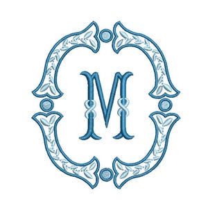 Könnte beinhalten: Ein gesticktes Monogramm des Buchstabens "M" in Hellblau, eingebettet in einen verzierten, ovalförmigen Rahmen. Der Rahmen weist dekorative Elemente auf, darunter Blätter und kreisförmige Akzente, alle in einem passenden Hellblau. Das Design befindet sich auf weißem Hintergrund.