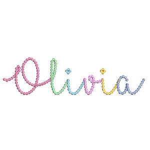 Peut inclure: Le prénom "Olivia" brodé dans un style cursif, utilisant une variété de couleurs pastel. Les lettres sont formées de petits points en forme de perles, avec des teintes roses, vertes, bleues et jaunes. Le fond est blanc uni.