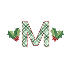 May include: A green and red plaid letter M with holly leaves and red berries on either side.