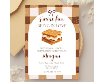 Puede incluir: Una tarjeta de invitación rectangular para despedida de soltera con un borde a cuadros marrón y blanco. El centro muestra una ilustración de un s'more con el texto S'more fun BEING IN LOVE, PLEASE JOIN US FOR A BRIDAL SHOWER HONORING Meagan, Saturday June 7th at 3pm, 123 Street Name, City, ST 12345, RSVP to 123-456-7890.