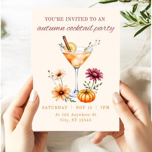May include: An invitation for an autumn cocktail party. The design features a watercolor illustration of a cocktail, flowers, and a pumpkin. The text reads "YOU'RE INVITED TO AN autumn cocktail party" and includes the date, time, and address.