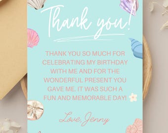 Puede incluir: Tarjeta de agradecimiento azul claro con ilustraciones de conchas marinas. La tarjeta dice "Thank you!" en escritura blanca, con un mensaje debajo agradeciendo al destinatario por celebrar un cumpleaños. Firmado "Love, Jenny."