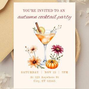 May include: An invitation for an autumn cocktail party. The design features a cocktail in a martini glass with a cinnamon stick and lemon slice. Orange and burgundy flowers and a small pumpkin are also included. The text reads: "YOU'RE INVITED TO AN autumn cocktail party".