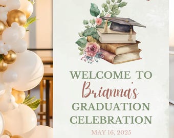 May include: A graduation celebration sign on an easel. The sign reads "A new chapter begins" above a stack of books, a graduation cap, and floral accents. The sign welcomes guests to Brianna's graduation celebration, dated May 16, 2025.