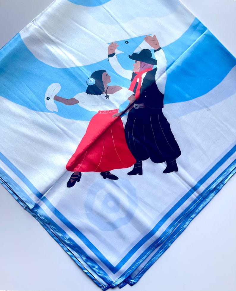 May include: Square white scarf with a blue and white design featuring a couple dancing. The woman wears a red skirt and white top, while the man wears black pants and a hat. The scarf has a blue border.