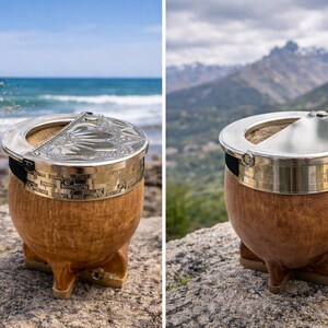 Może przedstawiać: Ręcznie wykonana tykwa do yerba mate z drewnianym korpusem, srebrną metalową obręczą i ozdobną pokrywką. Tykwa stoi na kamiennej powierzchni z rozmytym tłem oceanu. Projekt zawiera mosiężny pasek.