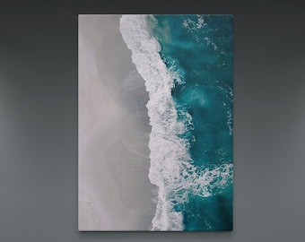 May include: An aerial view of a white sandy beach meeting turquoise ocean water with white foamy waves.