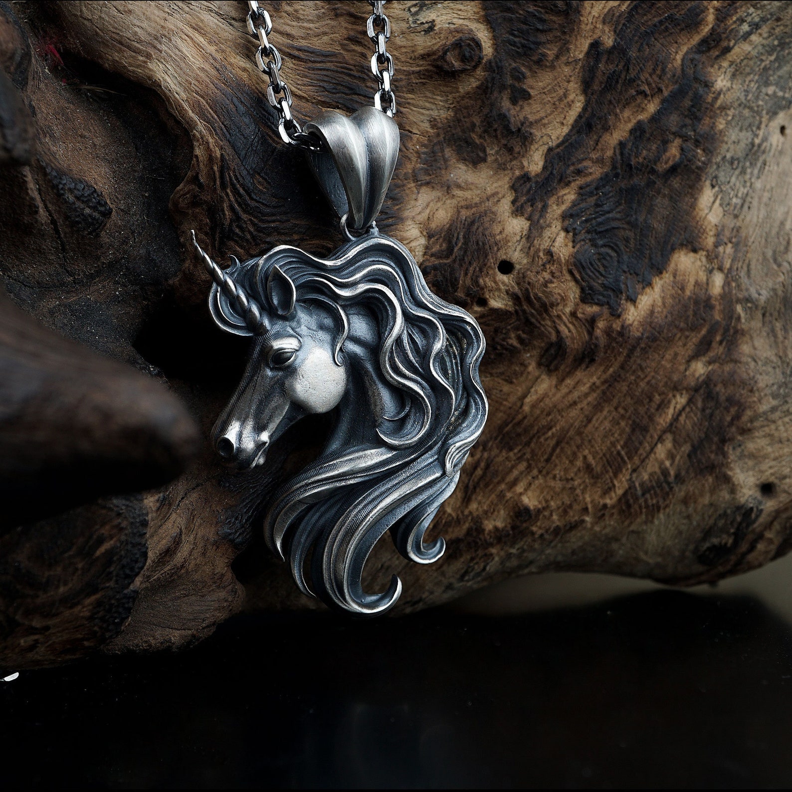 silver unicorn necklace, wood background