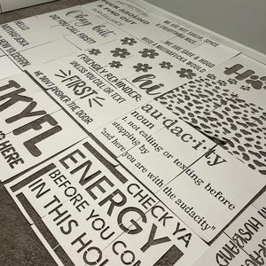 May include: A collection of white stencils with black text and various designs. The stencils feature phrases like "Energy Before You Come In This House" and "Audacity". Some stencils have floral and paw print designs.