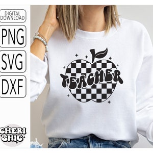 May include: A white sweatshirt with a black and white checkered apple design and the word "TEACHER" in a retro font.