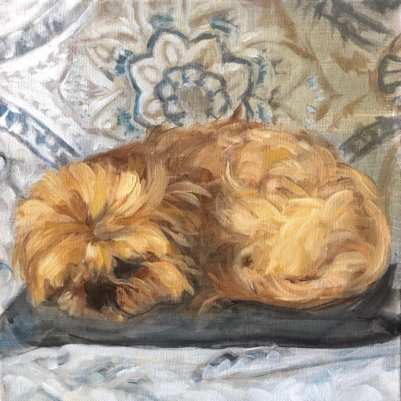 May include: An oil painting of a curled-up, fluffy, golden-brown dog resting on a gray pillow. The background features a patterned fabric with blue and white floral designs, creating a cozy and artistic scene.