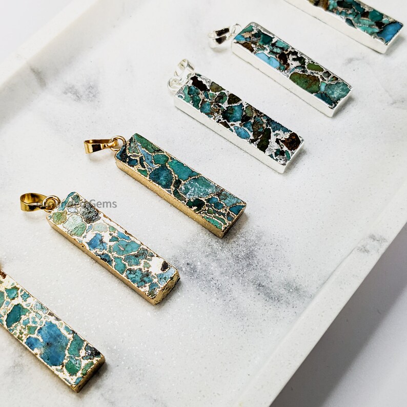 May include: Five gold and silver pendant charms with a turquoise and green marbled stone design. The pendants are rectangular in shape and have a gold or silver bail.