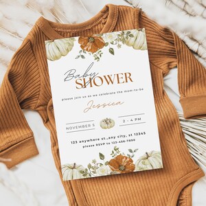 May include: A white baby shower invitation with a fall theme. The invitation features a watercolor illustration of pumpkins, flowers, and leaves. The text on the invitation reads "Baby Shower", "Please join us as we celebrate the mom-to-be Jessica", "November 5", "2-4 PM", "123 anywhere st., any city, st 12345", and "Please RSVP to 123-456-7890".