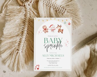 May include: A white baby sprinkle invitation with a green and pink colour scheme. The invitation features a gingerbread man, snowman, and reindeer with a festive garland and lights. The text reads "Please join us for a Baby Sprinkle honouring Ally Michaels February 20th | 1:00pm The Michaels Residence 123 anywhere st... City, State, Zip"
