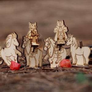 May include: Wooden game pieces featuring horses and cat-like characters. The horses have saddles and are in various poses. Red dice are scattered around the pieces. The pieces are made of light-colored wood.