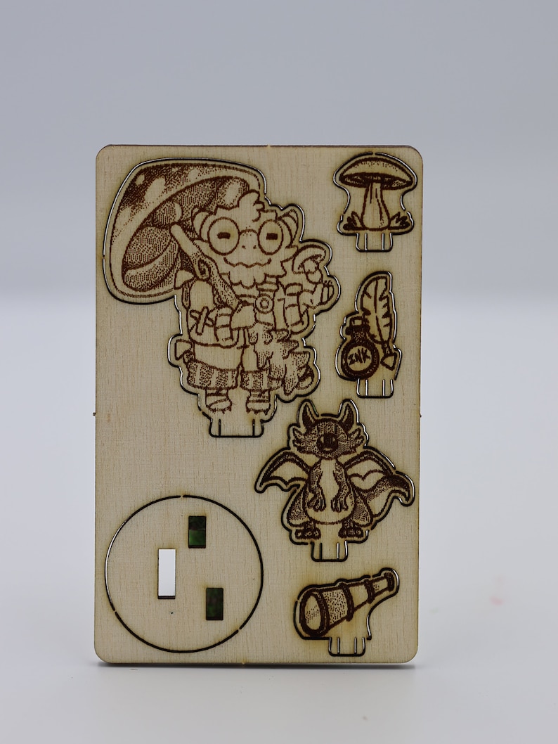 May include: A wooden cutout of a cartoon character with a mushroom hat, holding a magnifying glass and a bottle with a feather. The character is standing next to a dragon and a telescope. There is also a mushroom and a round cutout with two holes.
