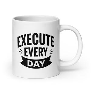 May include: White ceramic coffee mug with black text that reads "EXECUTE EVERY DAY" in a bold, sans-serif font.