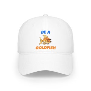 Può includere: Cappellino da baseball bianco con il testo "BE A GOLDFISH" in blu e arancione. Un pesce rosso dei cartoni animati con occhiali da sole è raffigurato sopra il testo.
