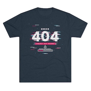 Op de afbeelding: Donker marineblauw t-shirt met een grafisch ontwerp. Het ontwerp toont de tekst "ERROR 404 ENERGY NOT FOUND" in het wit, met een glitch-effect. Daaronder staat een koffiekopje-icoon en een laadbalk met de tekst "RUNNING COFFEE BREW..."