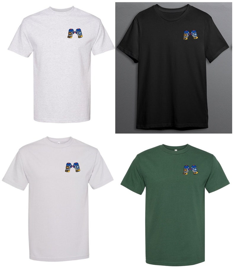 Op de afbeelding: Vier T-shirts in verschillende kleuren, elk met een klein geborduurd beeld van twee bokshandschoenen op de linker borst. De T-shirts zijn in grijs, zwart, wit en groen.