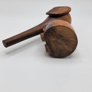 May include: A wooden elephant figurine with a brown finish. The elephant has a long trunk and a raised ear. The figurine is standing on a white surface.