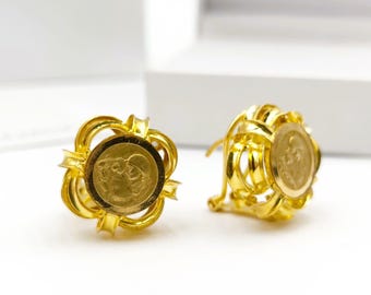 May include: A pair of gold earrings with a floral design. Each earring features a round coin with a detailed image of two people.