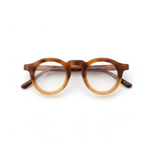 May include: Round-framed spectacles in a brown and tan gradient. The glasses feature a keyhole bridge and dark brown arms. The lenses are clear, and the design is classic and stylish. The frame is approximately 14 cm wide.