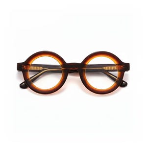 May include: Round-framed eyeglasses with a dark brown and amber color scheme. The glasses have a thick frame and a keyhole bridge. The lenses are clear. The temples are dark brown and have a subtle design. The overall style is vintage-inspired.