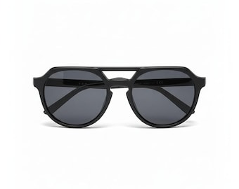 Könnte beinhalten: Schwarze Sonnenbrille mit einem einzigartigen geometrischen Rahmen. Die Sonnenbrille hat dunkle Gläser und einen Doppelsteg. Die Gesamtform ist eine Kombination aus runden und eckigen Elementen, die eine moderne Ästhetik schaffen. Auf weißem Hintergrund.