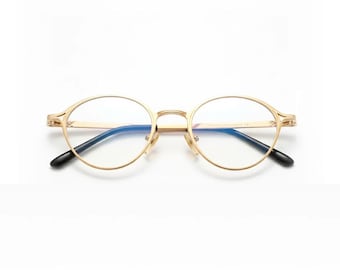 May include: Gold-rimmed eyeglasses with a classic oval shape. The frames are a shiny gold color, with black temple tips. The lenses are clear, with a slight blue tint. The glasses are set against a white background.