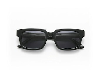 May include: Black square-framed sunglasses with dark lenses. The sunglasses have a thick, bold frame and a classic, timeless design. The lenses are dark, providing shade and protection from the sun. These sunglasses are a stylish accessory.