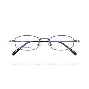 Könnte beinhalten: Ovale Brille mit einem dunkelgrauen Metallrahmen. Die Gläser sind klar, und die Bügel sind schwarz. Auf dem Rahmen steht das Wort "TITANIUM".