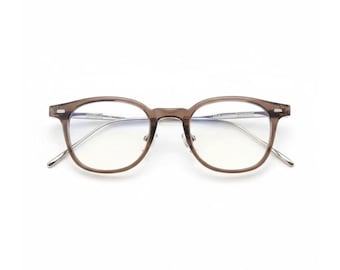 May include: A pair of eyeglasses with a brown frame and silver-colored arms. The lenses are clear, and the glasses have a classic, round shape. The glasses are set against a white background.