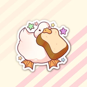 May include: A pink cartoon duck with a white beak and orange feet is holding a slice of bread in its beak. The duck is surrounded by colorful stars.