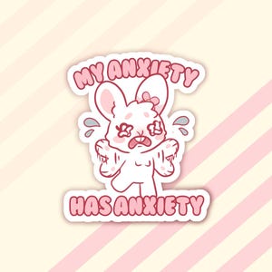 May include: A white sticker featuring a distressed cartoon bunny with the text "MY ANXIETY HAS ANXIETY" in pink. The bunny has tear drops and a worried expression, set against a striped background.