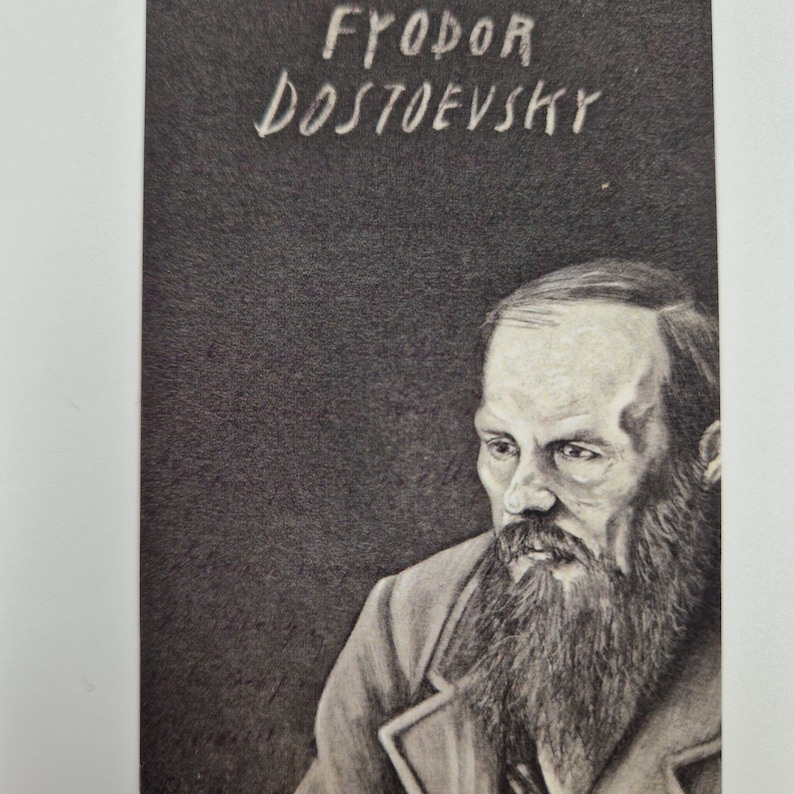 May include: Black and white portrait of Fyodor Dostoevsky, a Russian novelist, with a beard and a serious expression. The image is on a dark background with the name "FYODOR DOSTOYEVSKY" written in white.