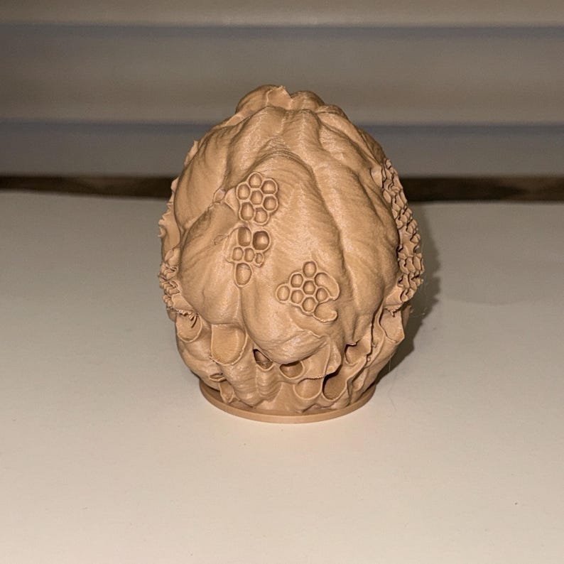 Peut inclure: Objet d&eacute;coratif imprim&eacute; en 3D de couleur beige, avec une surface textur&eacute;e. L'objet a une forme arrondie avec des motifs en nid d'abeille et d'autres textures organiques. Le design sugg&egrave;re un th&egrave;me naturel ou botanique.