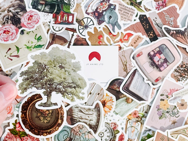 May include: A collection of vintage-style stickers featuring botanical illustrations, antique objects, and a tree. The stickers include images of flowers, a train, a car, and a clock. The text "JP ANIME LTD" is visible on a white card.