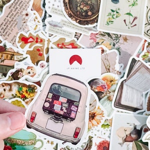 May include: A collection of vintage-style stickers featuring various designs. Includes a sticker of a light pink car with luggage, floral illustrations, dog illustrations, and a teacup. The stickers are in a variety of shapes and sizes.