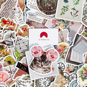 May include: A collection of vintage-style stickers with various designs, including floral arrangements, a cat with flower accents, a clock face, and text. The stickers have a distressed, aged appearance, with a mix of colors and illustrations.