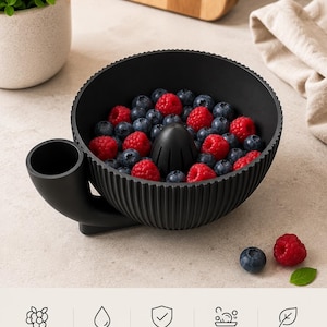 Puede incluir: Un cuenco negro acanalado para lavar bayas con un cono de drenaje central y un pico lateral. El cuenco está lleno de arándanos y frambuesas frescas. Debajo del cuenco, cinco iconos con los textos: Perfect for berries, Easy rinsing, Durable & lightweight, Easy to clean y BPA free.