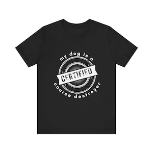 May include: Black t-shirt with a white graphic. The graphic is a circular design with the words "my dog is a" at the top, "CERTIFIED" in the center, and "course destroyer" at the bottom.
