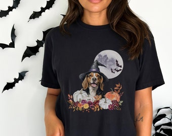 May include: A black t-shirt with a graphic of a beagle wearing a witch hat and surrounded by pumpkins and fall foliage. The graphic is set against a full moon with bats flying around it.