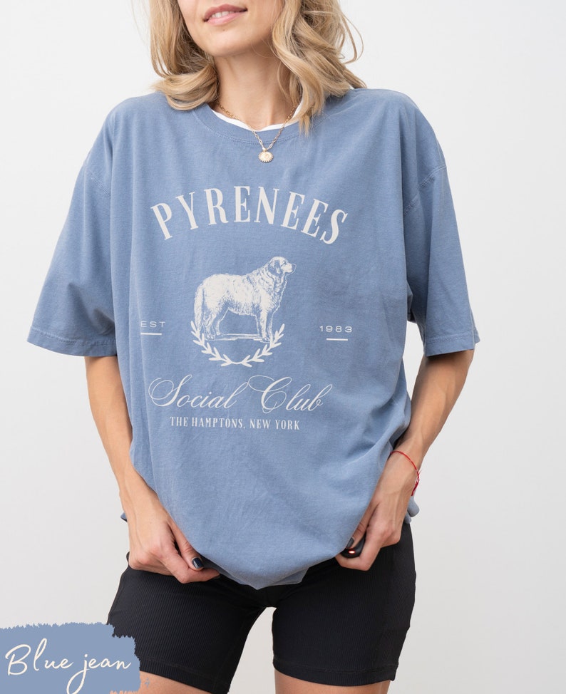 May include: A blue t-shirt with a white graphic of a sheep and the text "Pyrenees Social Club The Hamptons, New York"  EST 1983.