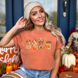 a woman wearing a t - shirt that says happy fall