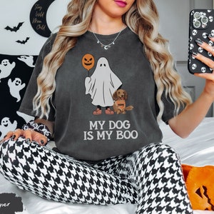 a woman sitting on a bed holding a cell phone